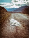 Rough road with pool and reflecting clouds Royalty Free Stock Photo