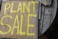 Plant Sale Spraypainted Wooden Sign on rustic round wood table with rock