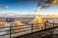 Rough seas batter the North Norfolk Coast, with waves breaking over the promenade and old Victorian pier at the holiday
