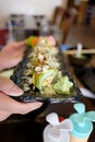 In selective focus a row of avocado roll sushi in a black tray Royalty Free Stock Photo