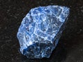 Rough Sodalite gemstone on black granite Royalty Free Stock Photo