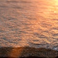 A rough stone surface is illuminated by a warm golden light, possibly from a setting Royalty Free Stock Photo