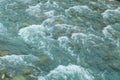 Rough surface of a mountain river. A rocky bottom shines through the clear water Royalty Free Stock Photo