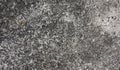 Rough texture of a loft wall made of small black pebbles in gray cement. Photo of a crumbling stone wall made of cement and small Royalty Free Stock Photo