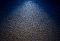 The rough-textured concrete patterned background on a dark blue wall provide a backdrop of bright light and shadow Royalty Free Stock Photo