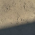 Rough-textured concrete surface in neutral tones, possibly beige or light gray. Surface Royalty Free Stock Photo