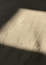 Rough-textured fabric surface in neutral tones, illuminated partially by a square of Royalty Free Stock Photo