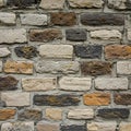 Rough-textured masonry wall composed of rectangular stones in varied shades of Royalty Free Stock Photo