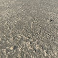 Rough-textured surface, possibly concrete or asphalt. Close-up view shows a grainy, Royalty Free Stock Photo