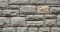 Rough textured wall made of rectangular, irregularly surfaced stone blocks in varying shades of Royalty Free Stock Photo
