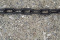 Rough and tough chain on concrete ciment texture background Royalty Free Stock Photo