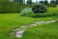 Rough trail different shapes natural stone path paved in the green backyard turf lawn. Royalty Free Stock Photo