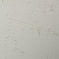 Rough white plaster wall surface exhibits peeling and cracking. The texture is uneven Royalty Free Stock Photo