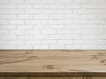 Rough wooden texture table over defocused white brick wall background Royalty Free Stock Photo