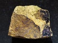 rough yellow Chalcopyrite stone on dark