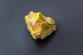 Rough yelow opal crystal, unpolished mineral. Close-up, black background