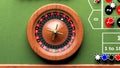 Roulette wheel on green table, poker chips Royalty Free Stock Photo