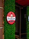Round advertising sign on background of green leaves of plants. Advertising dumplings. Logo Pelmeni.rf.