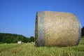 A round bale of hay on a freshly mown meadow against a blue sky Royalty Free Stock Photo