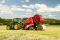 A round baler discharges a hay bale during harvesting