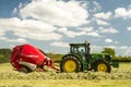 A round baler discharges a hay bale during harvesting Royalty Free Stock Photo