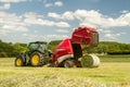 A round baler discharges a hay bale during harvesting Royalty Free Stock Photo