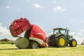 A round baler discharges a hay bale during harvesting Royalty Free Stock Photo