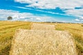 Round bales of hay on farmland with blue cloudy sky Royalty Free Stock Photo