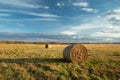 Round bales of hay lying on the meadow and clouds on the sky Royalty Free Stock Photo