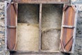 Round bales of hay stacked in an old stone farm with wooden doors. Royalty Free Stock Photo