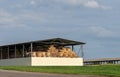 Round bales of straw are stored under a shed. Royalty Free Stock Photo