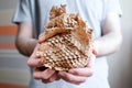 Round ball of brown paper in the hands. Thin mesh of brown paper. Side view