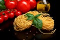 Round balls of pasta with tomatoes,basil,olive oil on black Royalty Free Stock Photo