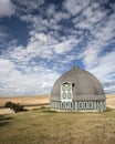 Round barn against a blue sky.