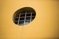 Round barred window in the wall of Royalty Free Stock Photo
