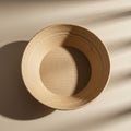 A round, beige paper bowl placed on a smooth, light-colored surface. The bowl has Royalty Free Stock Photo