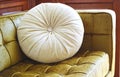Round beige pillow on golden velor sofa Royalty Free Stock Photo