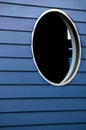 A round black window in a blue wall Royalty Free Stock Photo