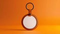 Round blank white leather keychain with metal ring on orange surface key ring circle Royalty Free Stock Photo