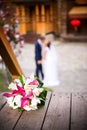 Round bouquet of white roses on a background of kissing newlyweds