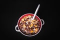 Round bowl with colorful cornflakes and milk and a spoon isolated on black Royalty Free Stock Photo