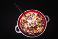 Round bowl with colorful cornflakes and milk and a spoon isolated on black Royalty Free Stock Photo