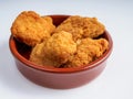 A round bowl of crispy fried chicken nuggets on a white background Royalty Free Stock Photo