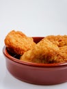 A round bowl of crispy fried chicken nuggets on a white background Royalty Free Stock Photo