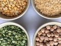 Round bowls with different legumes on a white background