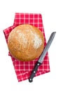 Round bread with knife on checkered napkin Royalty Free Stock Photo
