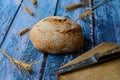 Round bread, rustic background, knife on wooden cutting board. Royalty Free Stock Photo