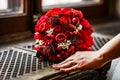 Round bridal bouquet of bright red roses and berries