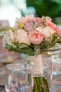 Round bridal bouquet featuring pastel color peonies and roses, lace and greenery, set on a table, with selective focus