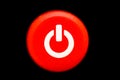 Round bright red power on and off button or switch with white power symbol macro photography